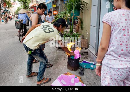 Vietnamese people burning paper in the street for Hungry Ghost festival, Hai Phong, Vietnam Stock Photo