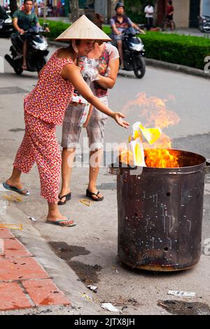 Vietnamese people burning paper in the street for Hungry Ghost festival, Hai Phong, Vietnam Stock Photo