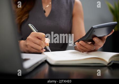 Close-up image of business lady making calculations and taking notes Stock Photo