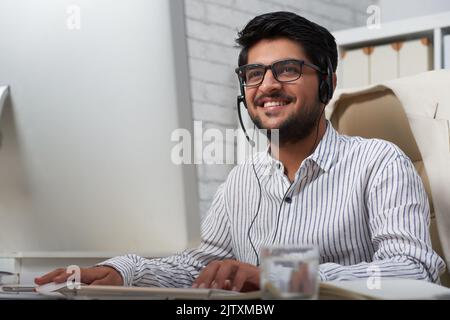 Handsome Indian customer support operator at his table Stock Photo