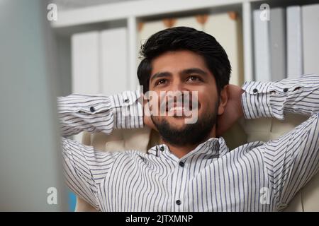Portrait dreamy Indian businessman resting in his chair Stock Photo
