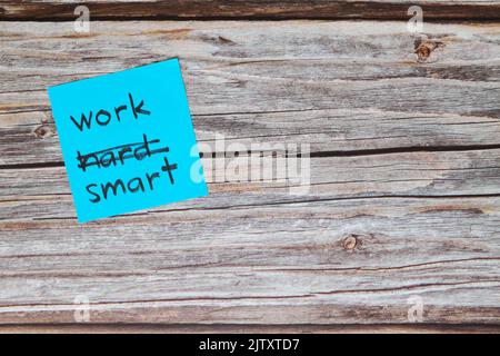 Work smart not hard concept. Sticky note reminder on wooden background. Stock Photo