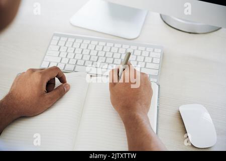 Close-up of man writing in his notebook Stock Photo