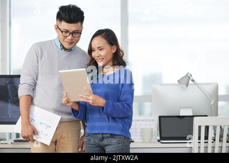 Business young people using tablet while standing at office Stock Photo