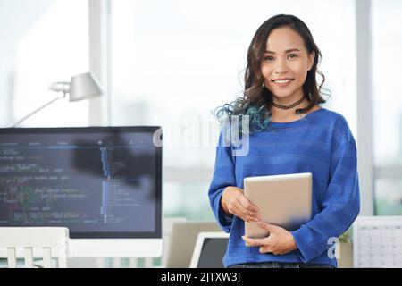 Portrait of smiling businesswoman holding tablet at office Stock Photo