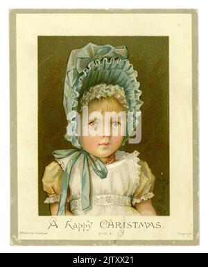 Charming original Victorian Christmas card. traditional Victorian greetings card of cute serious looking young Victorian girl, her face framed by a large pale blue bonnet. This card was published by Hildesheimer and Faulkner. Dated Xmas 1886. Stock Photo