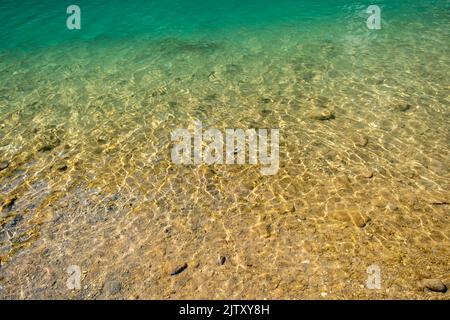 Ripple water abstract background with small pebbles Stock Photo