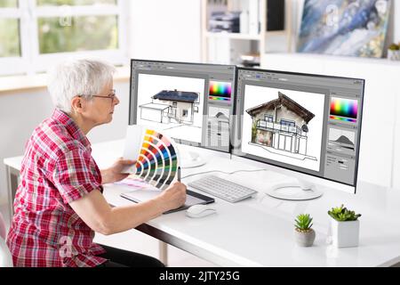 Website Graphic Designer Working In Office On Multiple Screens Stock Photo