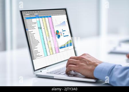 Hand Using Laptop For Spreadsheet Data Work Stock Photo
