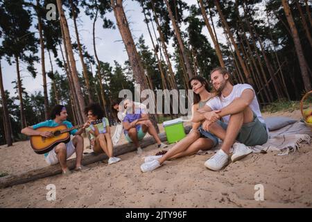 Full body photo of millennial ladies guys sit listen music wear casual cloth holiday outdoors Stock Photo