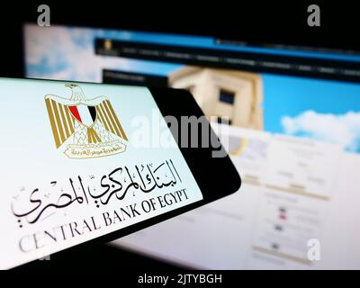 Cellphone with logo of monetary authority Central Bank of Egypt (CBE) on screen in front of website. Focus on right of phone display. Stock Photo