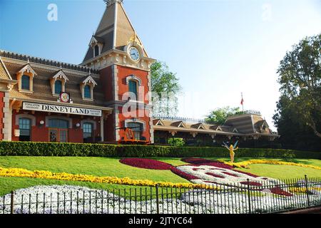 A depiction of Mickey Mouse, made of flowers in a garden, stands in front of the Disneyland train station near the entrance to the amusement park Stock Photo