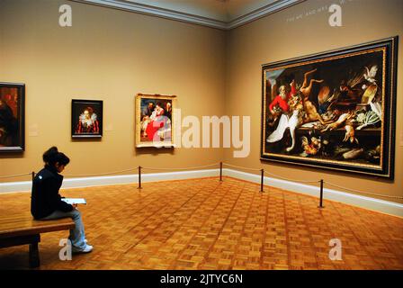 A lone woman sketches a large painting hanging in the Art Institute of Chicago museum Stock Photo