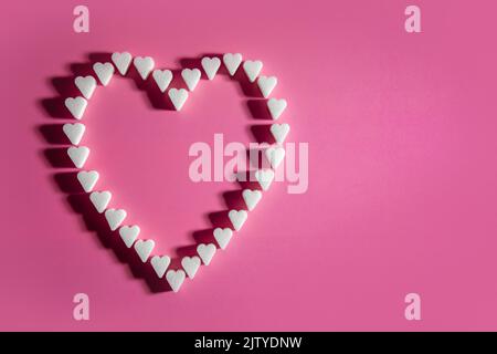Heart made of sugar cube hearts on pink background Stock Photo