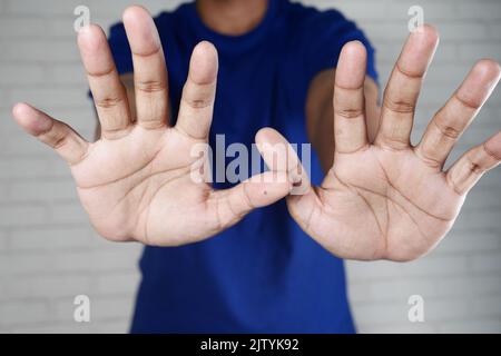 young man show stop sigh isolated in black  Stock Photo