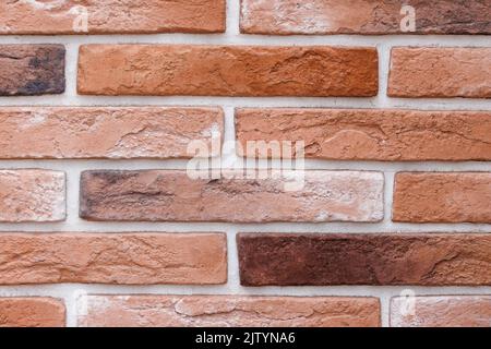 fake brick wall, plastic panel imitating natural brickwork with white seams Stock Photo