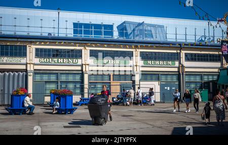 An employee pushes a large bin of rubbish at Adventure Island, a funfaior and theme park located on the seafront next to Southend Pier in Essex, UK. Stock Photo