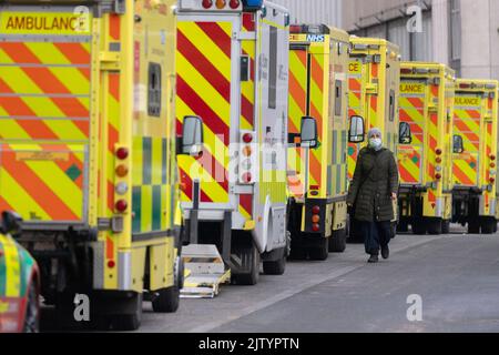 (220902) -- BEIJING, Sept. 2, 2022 (Xinhua) -- Photo taken on Jan. 28, 2022 shows a woman walking past ambulances parked outside the Royal London Hospital in London, Britain. (Photo by Ray Tang/Xinhua) Stock Photo