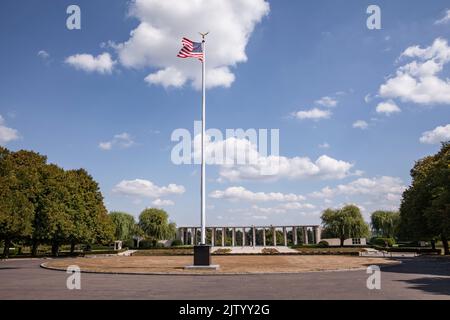 Henri-Chapelle American Cemetery and Memorial, US military cemetery near Welkenraedt, Wallonia, Belgium. Tall pole with Stars and Stripes flag and gol Stock Photo