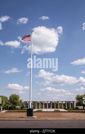 Henri-Chapelle American Cemetery and Memorial, US military cemetery near Welkenraedt, Wallonia, Belgium. Tall pole with Stars and Stripes flag and gol Stock Photo