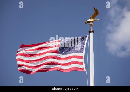 Henri-Chapelle American Cemetery and Memorial, US military cemetery near Welkenraedt, Wallonia, Belgium. Tall pole with Stars and Stripes flag and gol Stock Photo