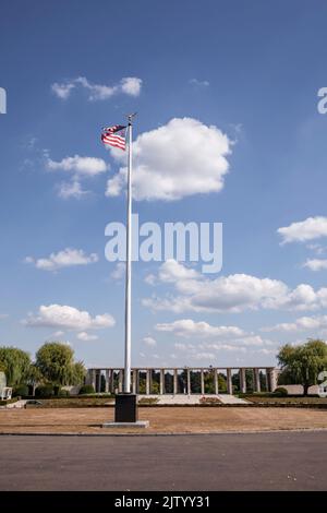 Henri-Chapelle American Cemetery and Memorial, US military cemetery near Welkenraedt, Wallonia, Belgium. Tall pole with Stars and Stripes flag and gol Stock Photo