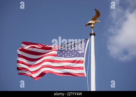 Henri-Chapelle American Cemetery and Memorial, US military cemetery near Welkenraedt, Wallonia, Belgium. Tall pole with Stars and Stripes flag and gol Stock Photo