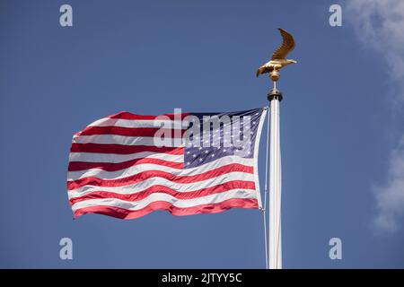 Henri-Chapelle American Cemetery and Memorial, US military cemetery near Welkenraedt, Wallonia, Belgium. Tall pole with Stars and Stripes flag and gol Stock Photo