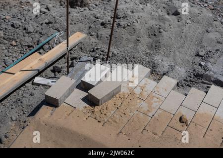 Pavement repair and laying of paving slabs on the walkway, stacked tile cubes on the background. Laying paving slabs in the pedestrian zone of the Stock Photo