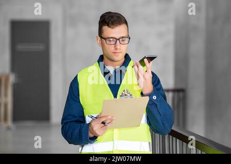 male architect with clipboard calling on phone Stock Photo