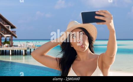 smiling woman in bikini taking selfie on beach Stock Photo