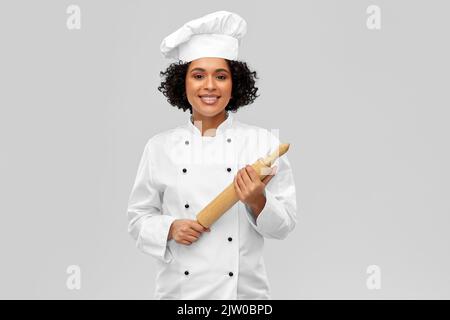 smiling female chef or baker with rolling pin Stock Photo