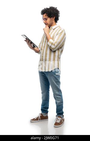 thinking young man in glasses with tablet computer Stock Photo