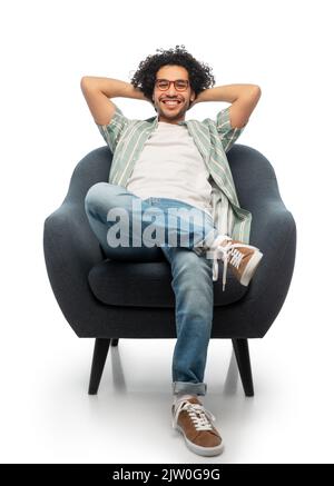 happy smiling young man sitting in chair Stock Photo