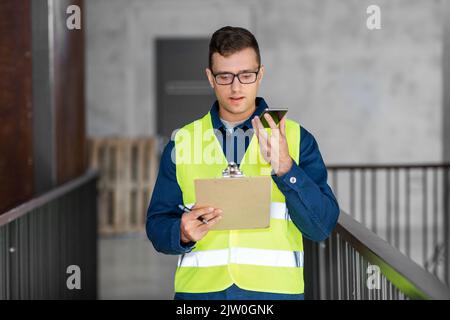 male architect with clipboard calling on phone Stock Photo
