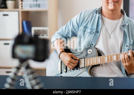 man with camera playing guitar and recording video Stock Photo
