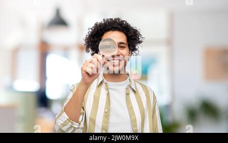 happy man looking through magnifying glass Stock Photo