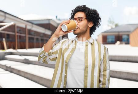 man drinking coffee from paper cup in city Stock Photo
