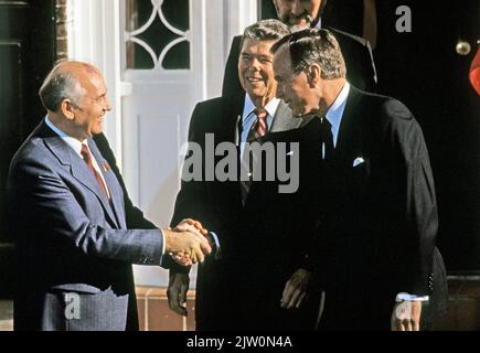 United States President-elect George H.W. Bush, right, shakes hands with General Secretary Mikhail Gorbachev of the Union of Soviet Socialist Republics, left, as US President Ronald Reagan looks on, center, as they meet on Governor's Island in New York, New York on December 7, 1988.Credit: Arnie Sachs / CNP /MediaPunch Stock Photo