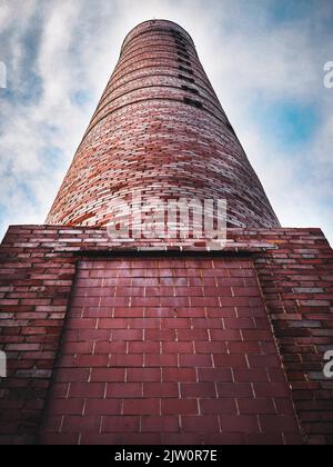 A tall brick factory smoke stack billowing with steam and smoke Stock ...
