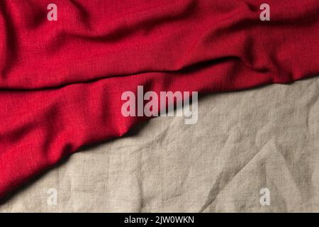 Abstract linen fabric texture background. Crumpled natural linen organic eco textiles canvas background in red and beige brown colors. Top view Stock Photo