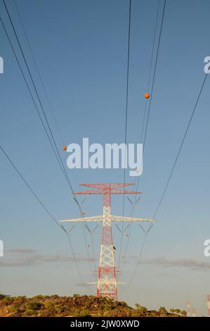 A vertical low angle shot of an electricity power pylon with cables on it Stock Photo