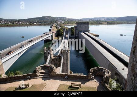 The Three Conwy Bridges, suspension, rail and new road bridge at Conwy, North Wales viewed from a turret in Conwy Castle during summer Stock Photo