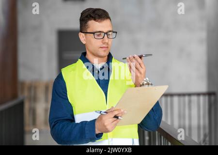 male architect with clipboard calling on phone Stock Photo