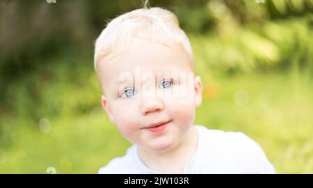 Close up headshot of a young blonde male looking into the camera. Stock Photo