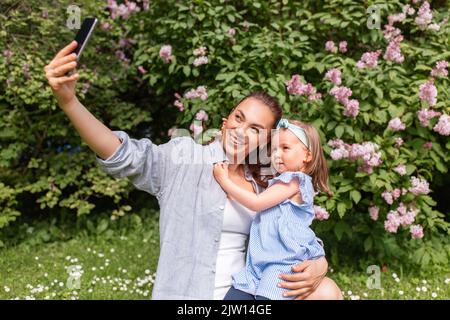 happy mother with daughter taking selfie at park Stock Photo
