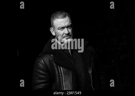 Middle-aged male looking into camera with a pose, studio light used. Stock Photo