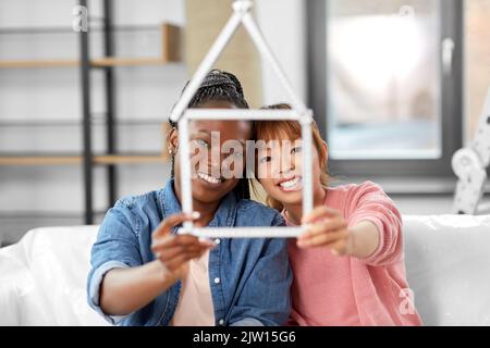 happy smiling women with ruler in shape of house Stock Photo