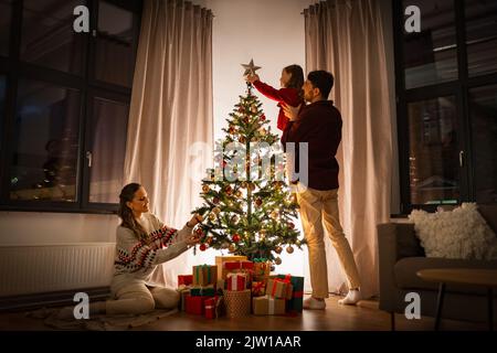 happy family decorating christmas tree at home Stock Photo