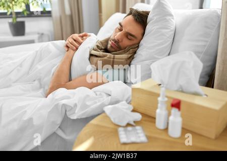 sick man with medicines on table sleeping in bed Stock Photo